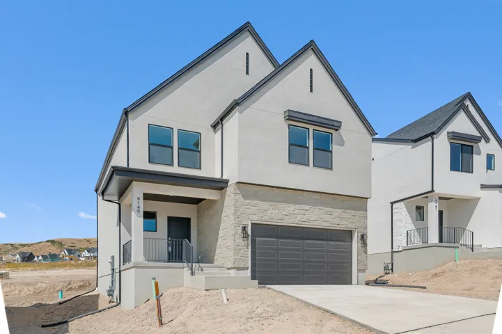 Modern exterior with light stucco, stone veneer, and a dark asphalt shingle roof