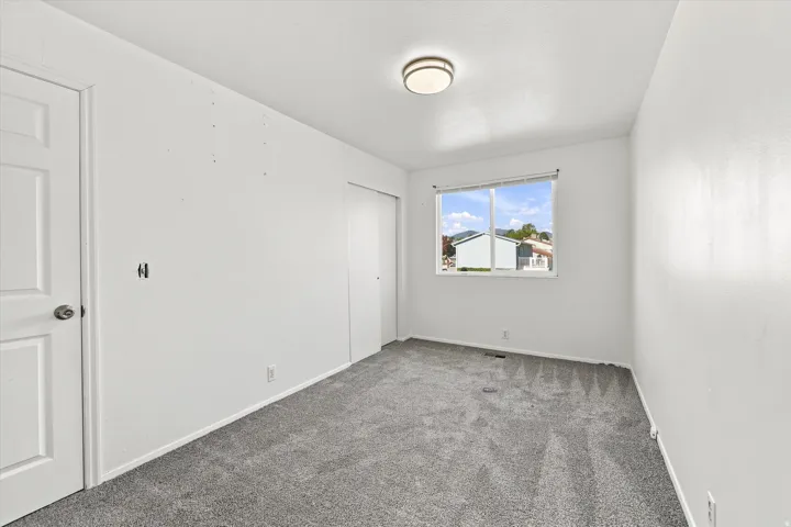 Neutral-toned carpeting, ample natural light, and a flush mount ceiling fixture