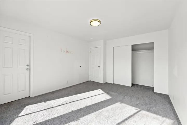 Wall-to-wall carpeting with a sliding door closet and paneled interior doors