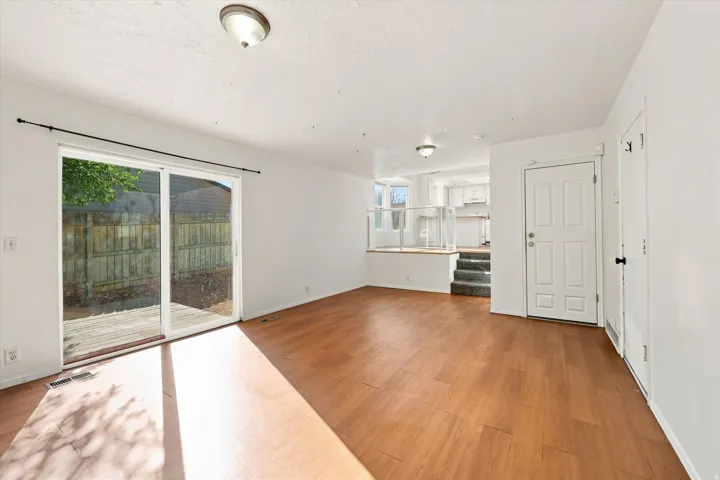 Wood-finish flooring, sliding glass patio door, white interior doors, and recessed ceiling lighting