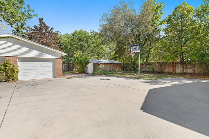 Detached two-car garage with overhead doors offering convenient access to the expansive concrete driveway