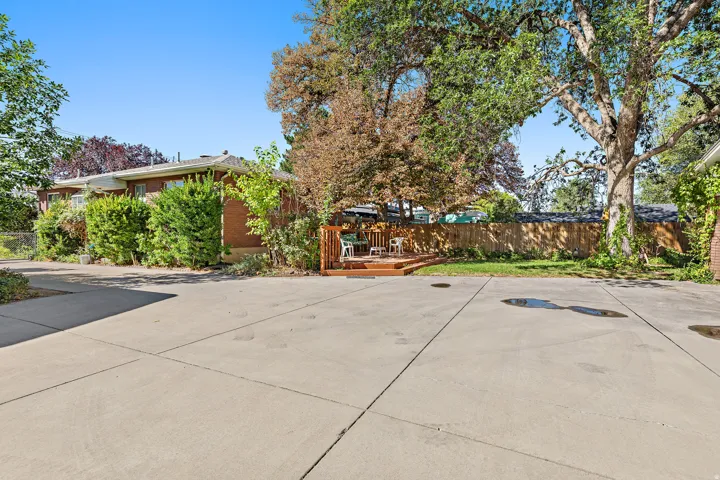 Expansive concrete paved area with a raised wood deck