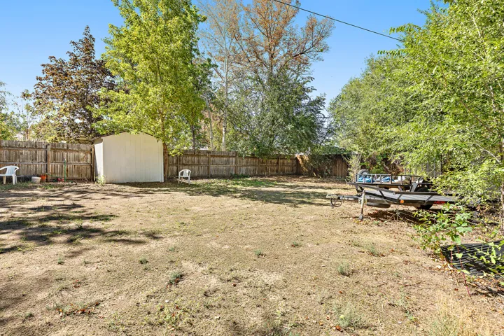 Expansive backyard featuring a wood privacy fence and a storage shed