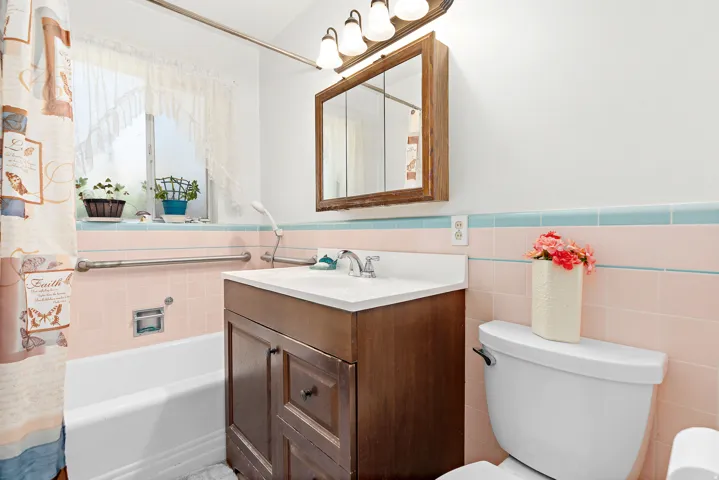 Main bathroom with a 'three-boy' tub, a white sink, and a mirrored medicine cabinet