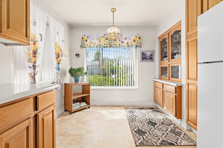 Built-in wooden cabinetry with glass-front uppers, ample counter space, and tiled flooring