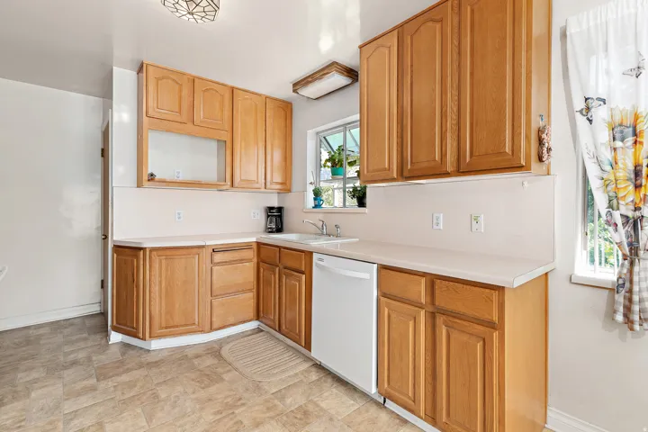 Laminate flooring, wood-finish cabinetry, and white countertops