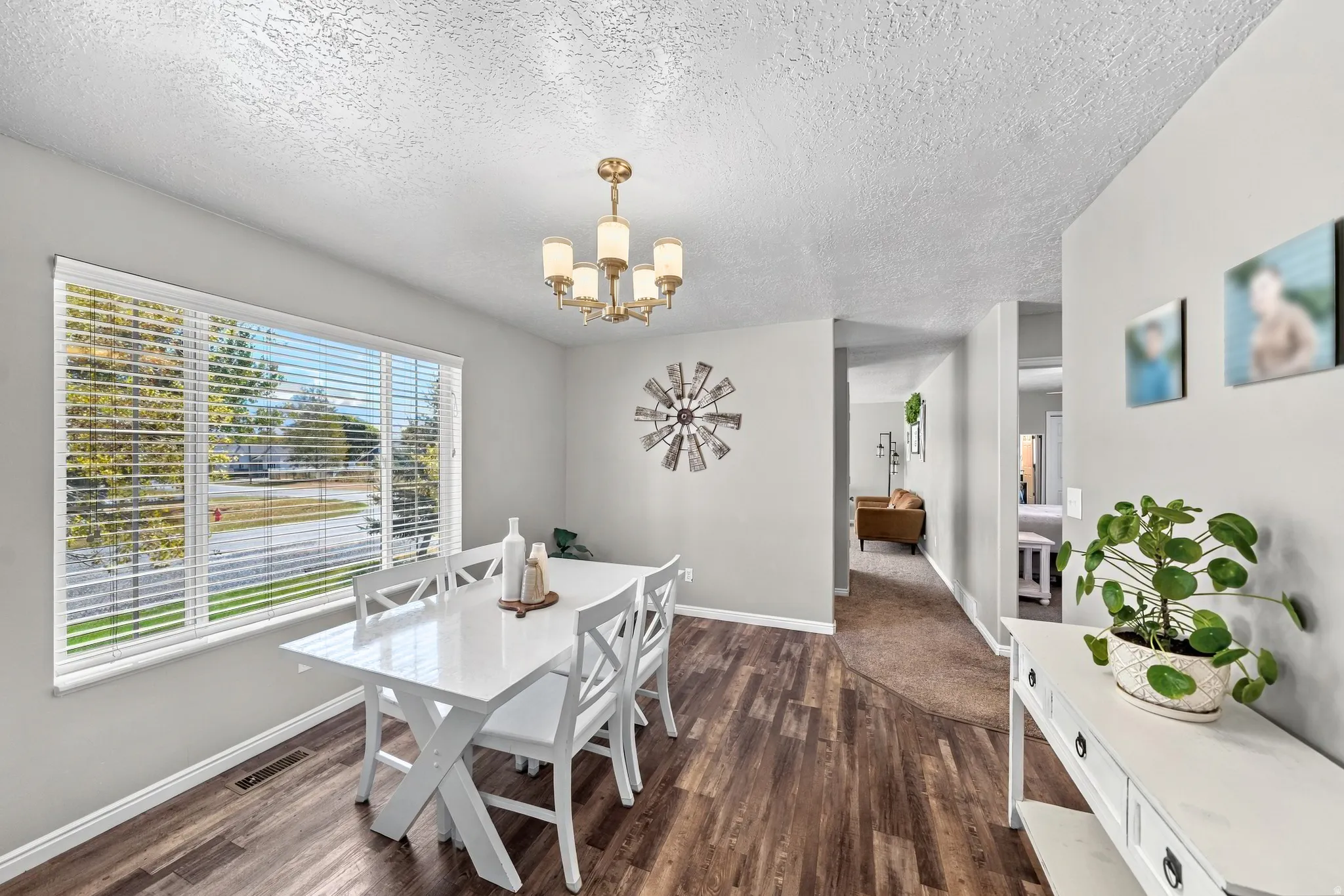 Spacious interior with wood-finish flooring, a large window, and a decorative chandelier