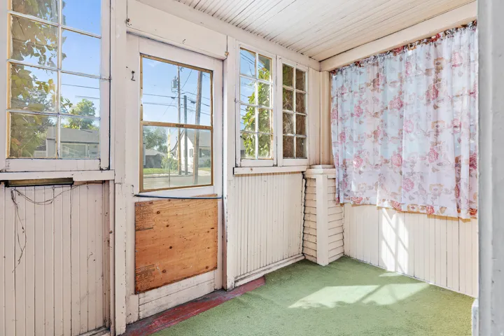 Enclosed porch featuring multiple pane windows and beadboard paneling