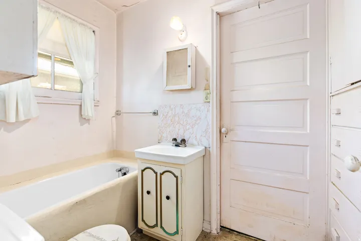 Pedestal sink with built-in cabinet, wall-mounted medicine cabinet, paneled interior door, and built-in storage drawers