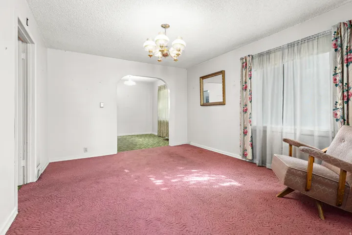 Arched doorway, textured ceiling, and chandelier lighting