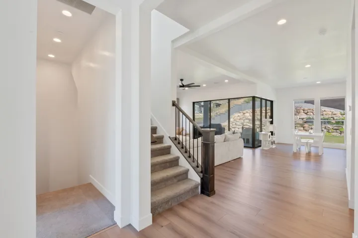 Open-concept living area featuring wood-finish flooring, recessed lighting, and expansive windows