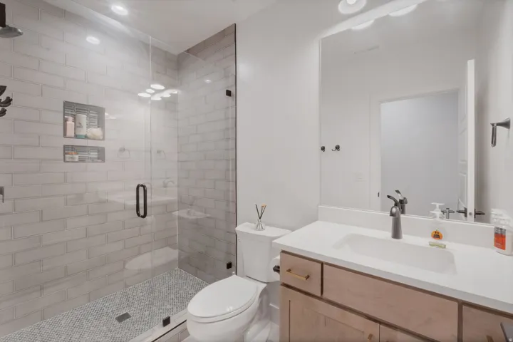 Glass-enclosed shower with subway tile surround and integrated shower niche