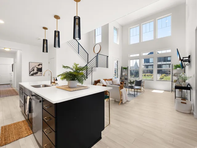 Gourmet kitchen island with white countertop, stainless steel sink, and sleek pendant lighting