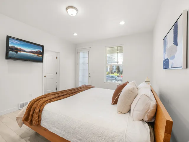 Light-filled room featuring recessed lighting, a ceiling-mounted light fixture, a paneled door, and wood-finish flooring