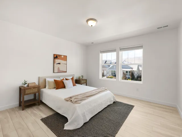 Bright interior with light wood-finish flooring, white walls, and dual windows