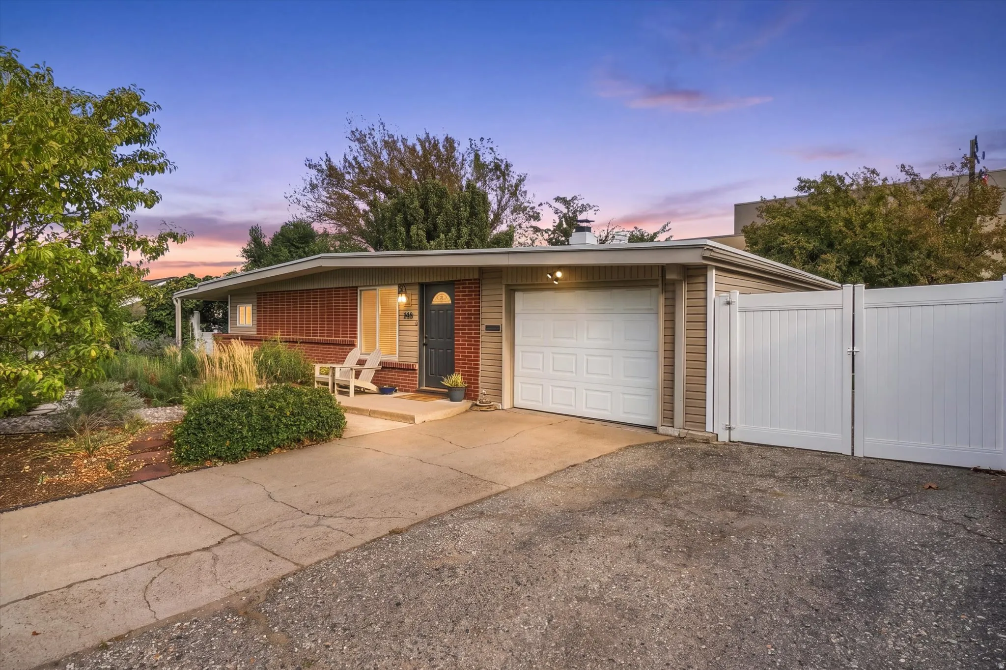 Single-story residence featuring a brick facade, attached garage, and a concrete driveway