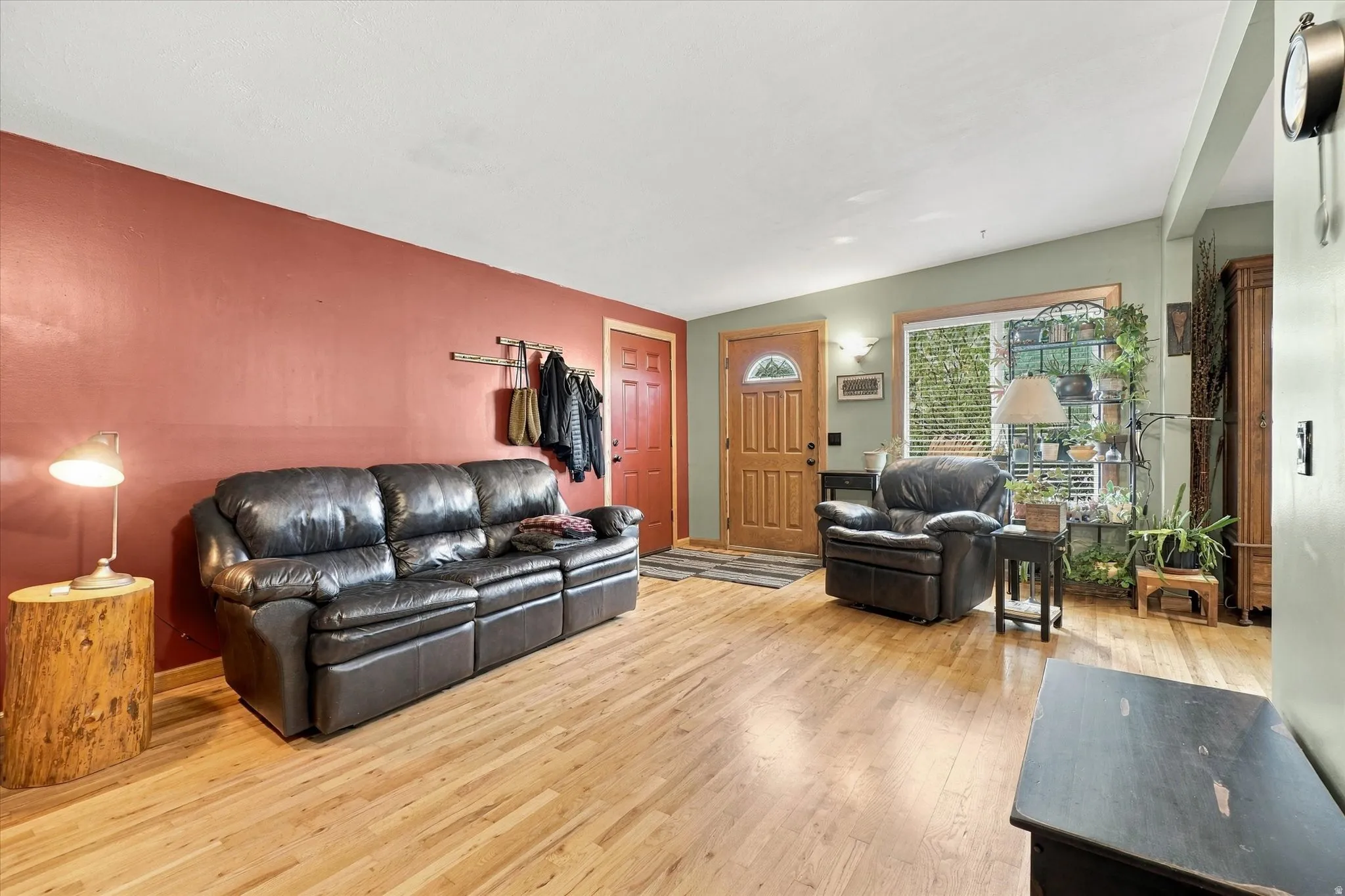 Hardwood flooring, painted walls, and a wood-paneled door with a decorative glass insert