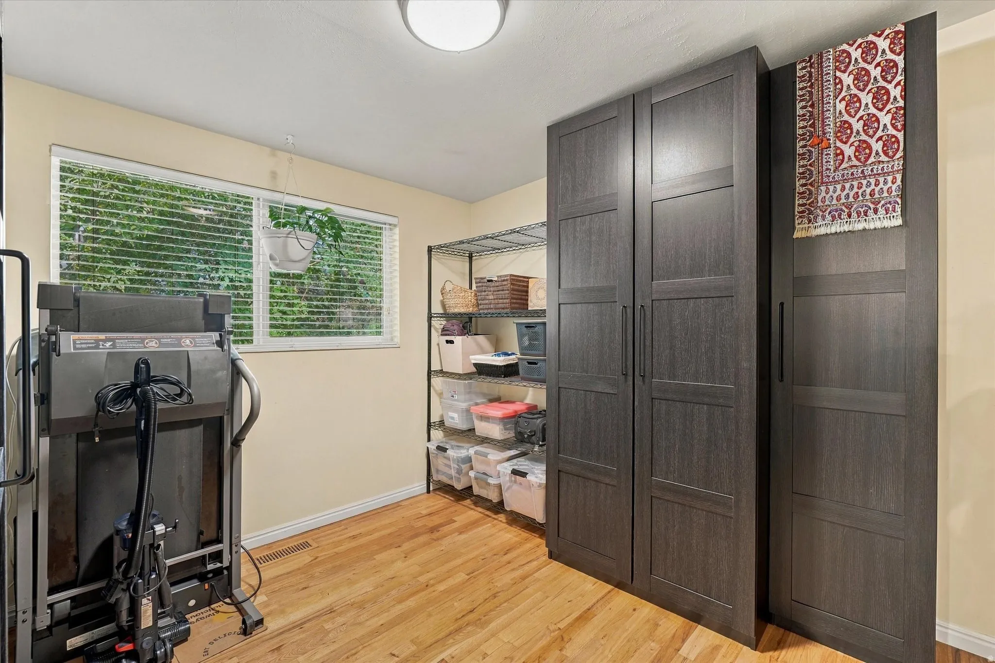 Wood-finish flooring, built-in storage cabinetry, white window blinds, and recessed lighting
