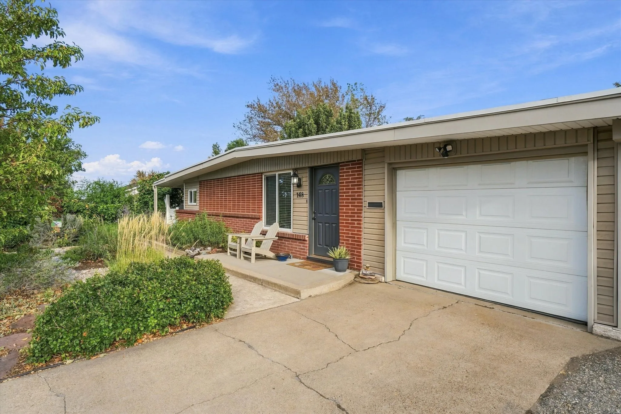 Brick and siding exterior with a concrete driveway and an attached garage