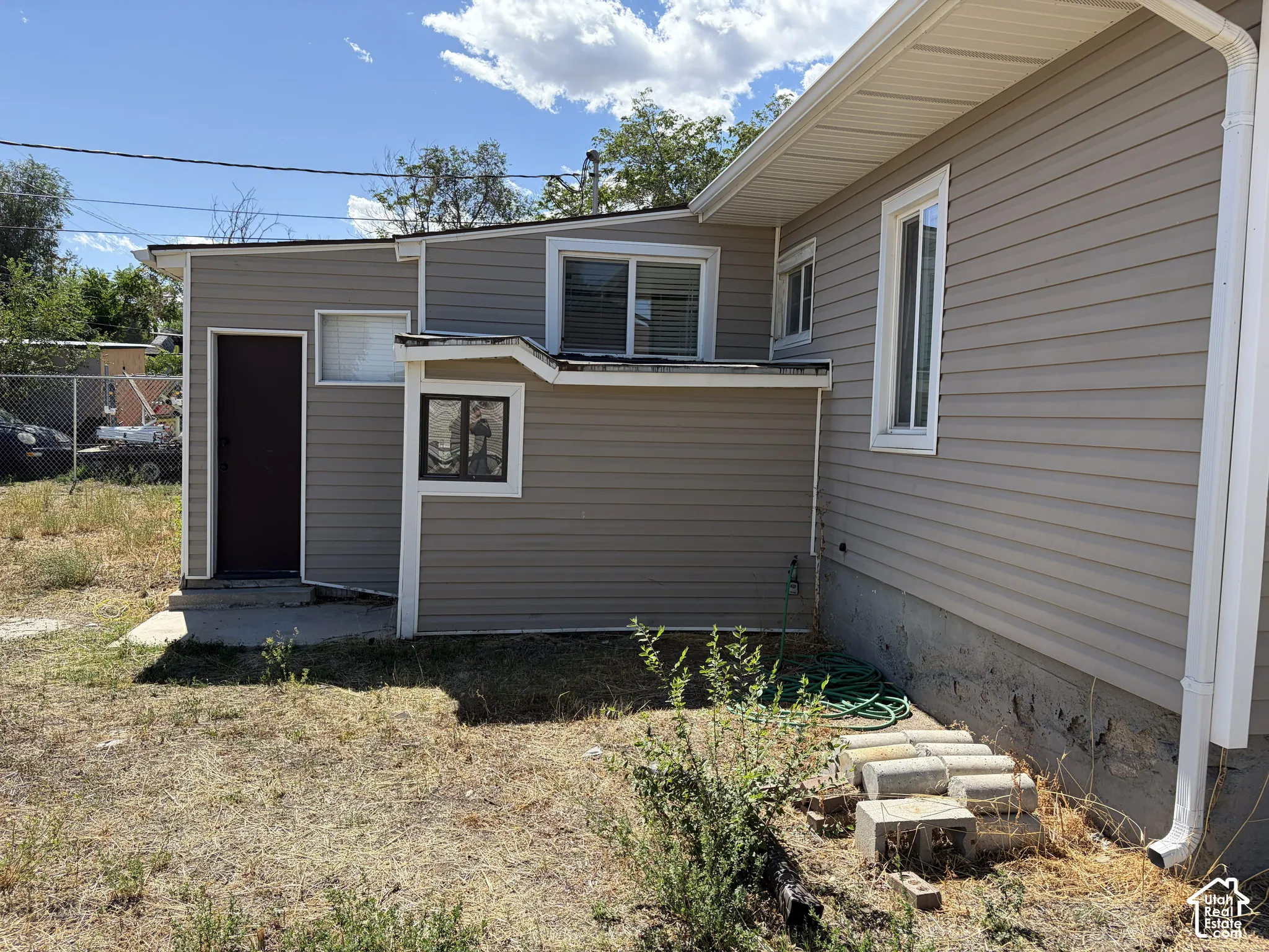 Vinyl siding exterior with white window trim and a detached structure