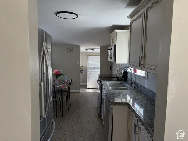 Modern kitchen featuring stainless steel appliances, dual basin sink, and granite countertops