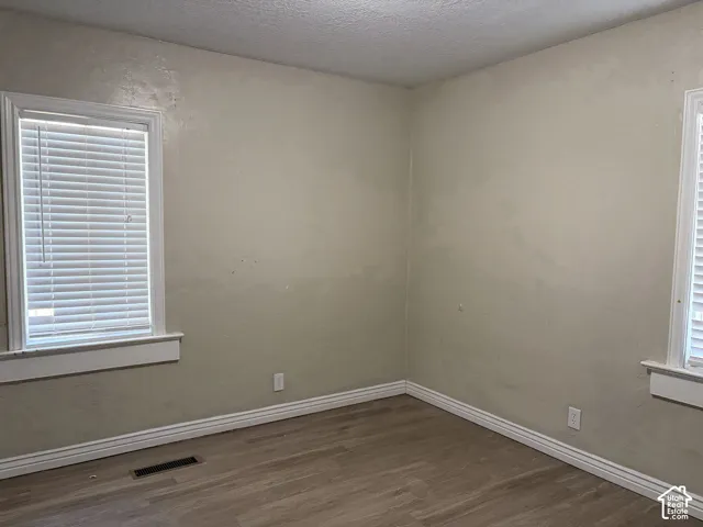 Wood-finish flooring with white trim and window casings