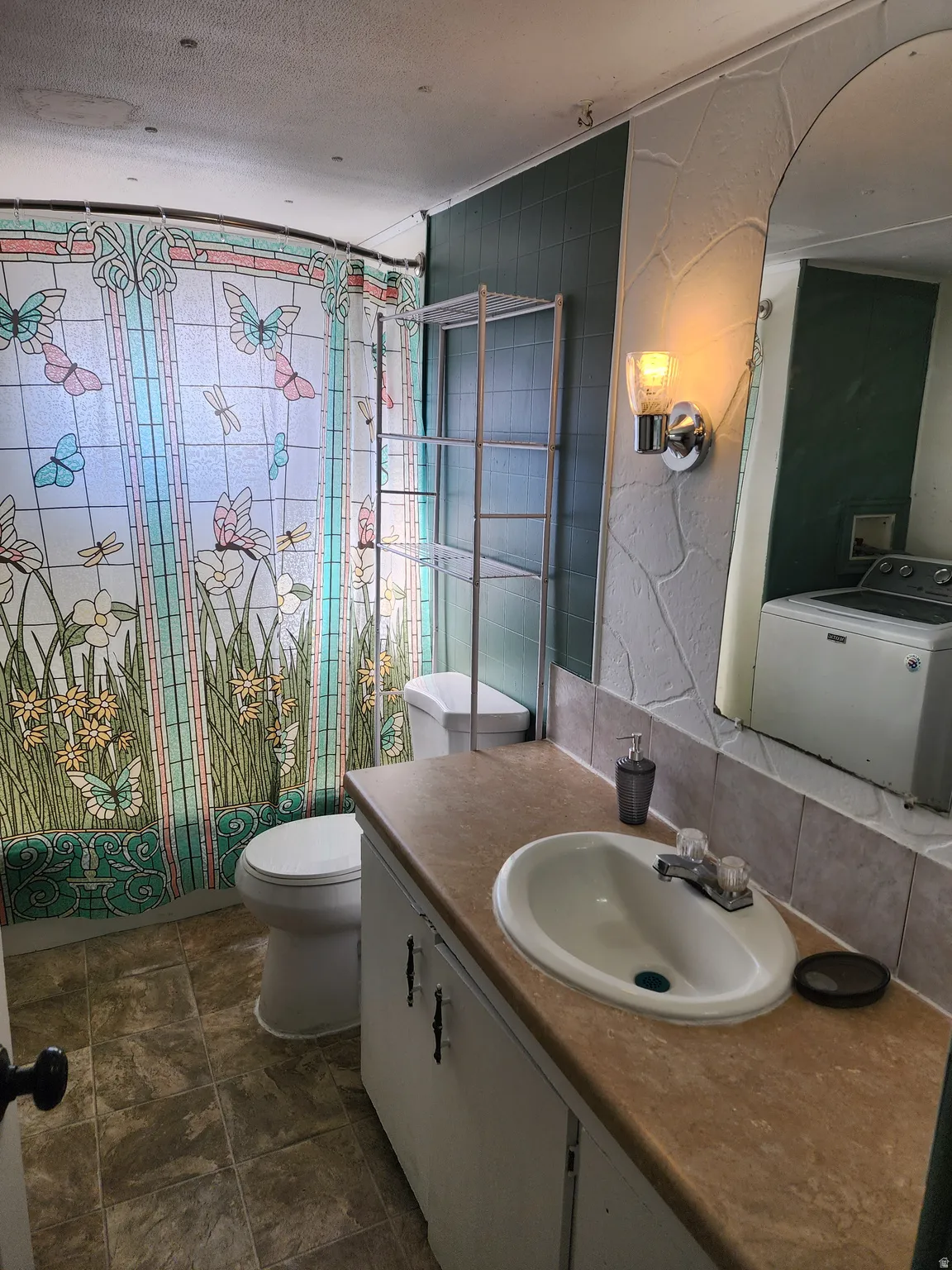 Vanity with an integrated sink, laminate countertop, and tile backsplash