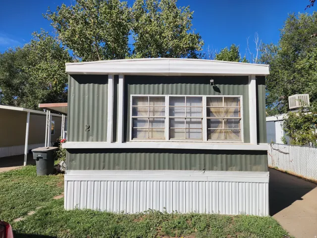 Green corrugated metal siding with white trim