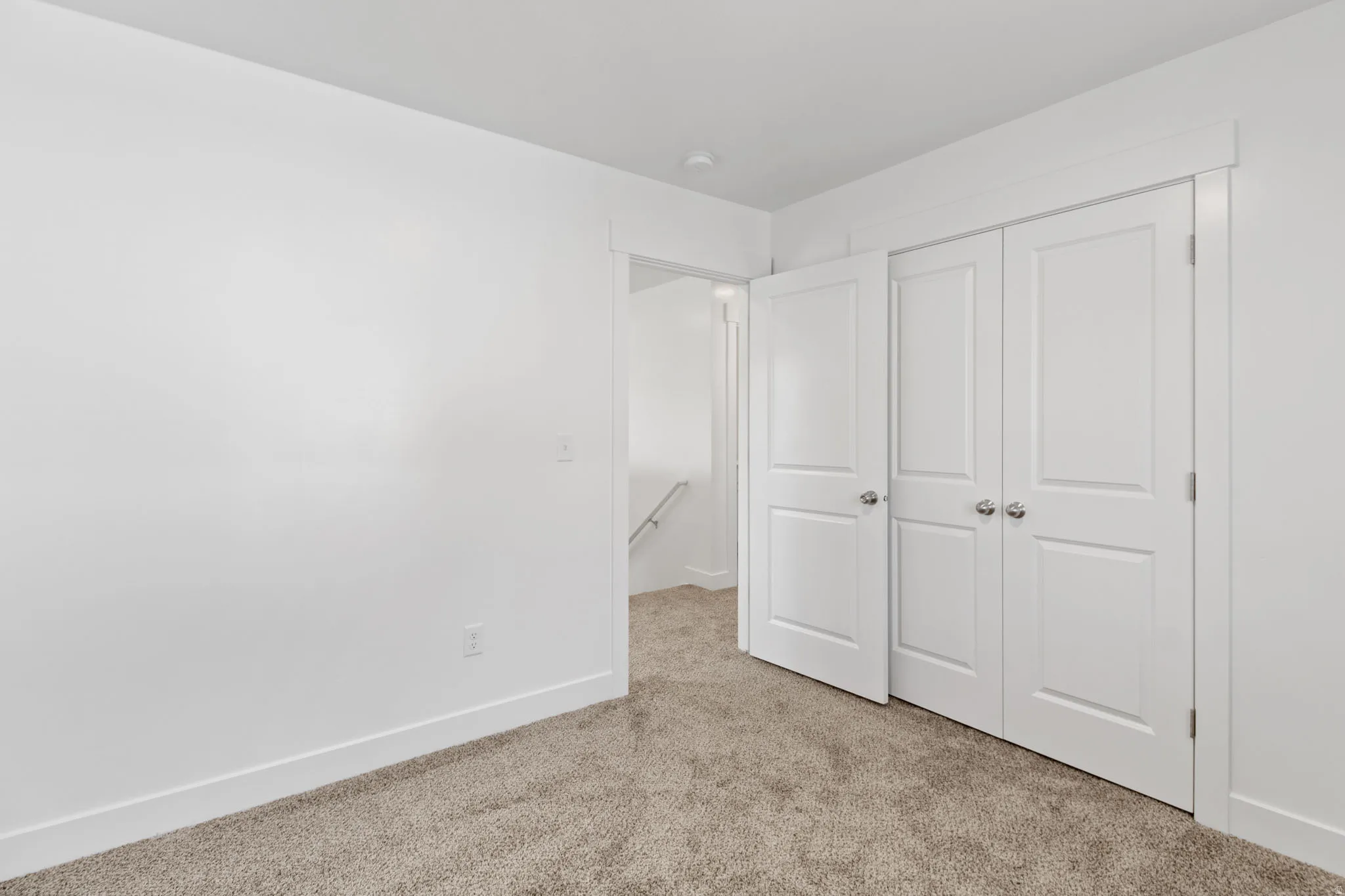 Neutral tone wall paint, textured carpet flooring, two-panel bifold closet doors, and recessed lighting
