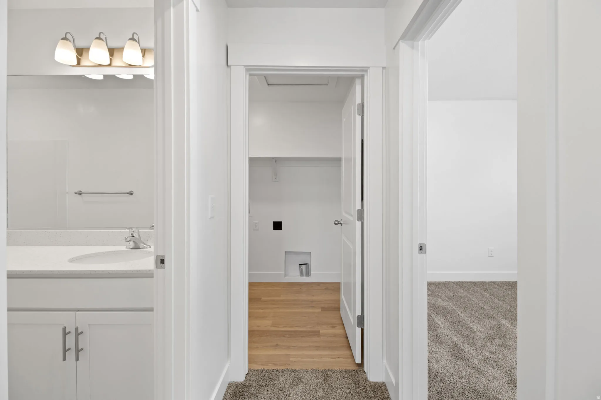 White vanity with a light-colored countertop and integrated sink