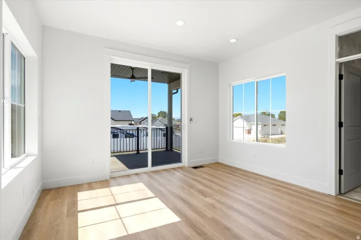 Wood-finish flooring, recessed lighting, and white walls