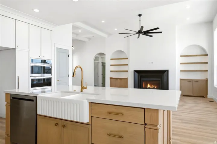 Central kitchen island with a fluted farmhouse sink and brass faucet