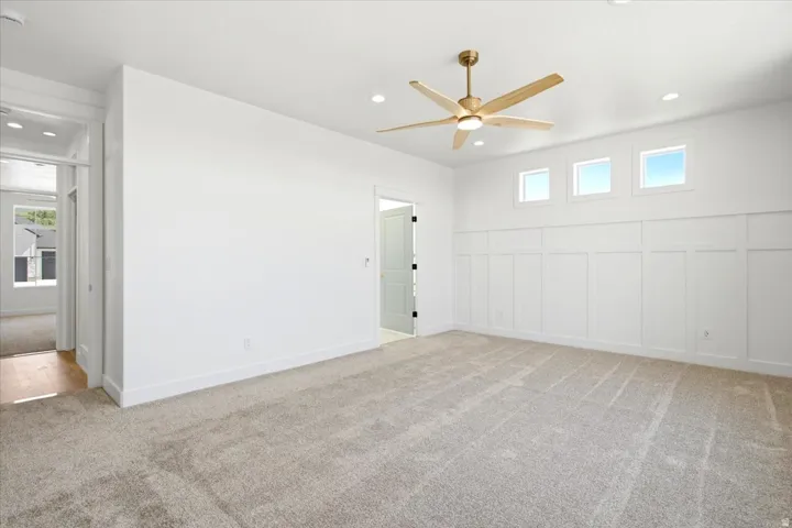 Neutral carpet flooring, recessed lighting, and a ceiling fan with integrated lighting