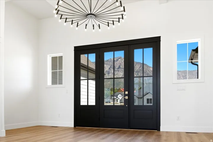 Vaulted ceilings, wood-finish flooring, and a modern sputnik chandelier
