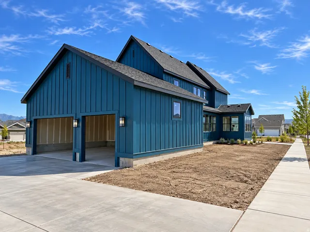 Modern farmhouse exterior with vertical panel siding, dark trim, and a two-car garage