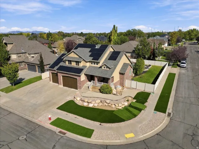 Brick and stucco exterior with multiple gables, an attached two-car garage, and extensive roof-mounted solar panels