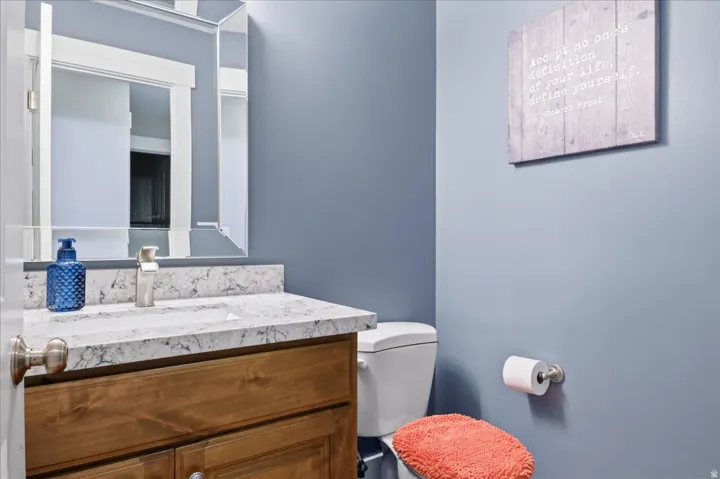 Vanity with a light-toned countertop, undermount sink, and wood-finish cabinetry