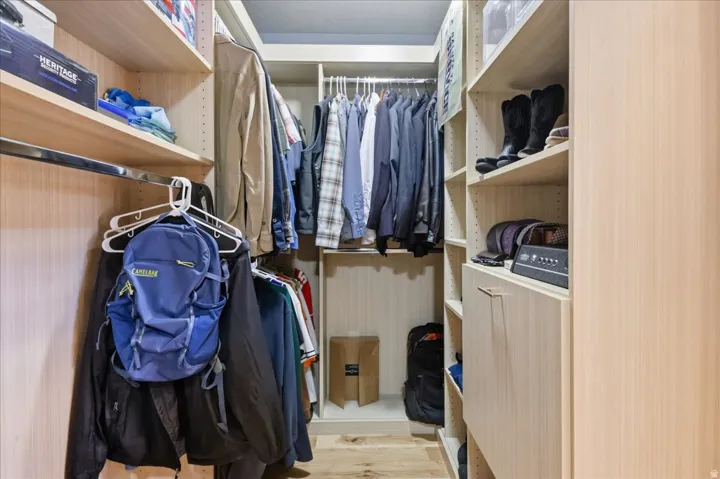 Custom closet system featuring multiple hanging rods, adjustable shelving, and integrated drawers