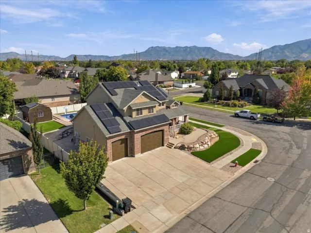 Two-story residence featuring a two-car garage, solar panel installation, a swimming pool, and an expansive concrete driveway