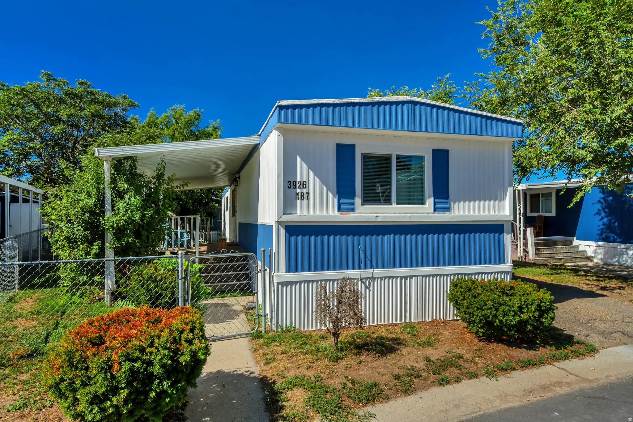 Blue and white exterior siding with white window trim and blue shutters