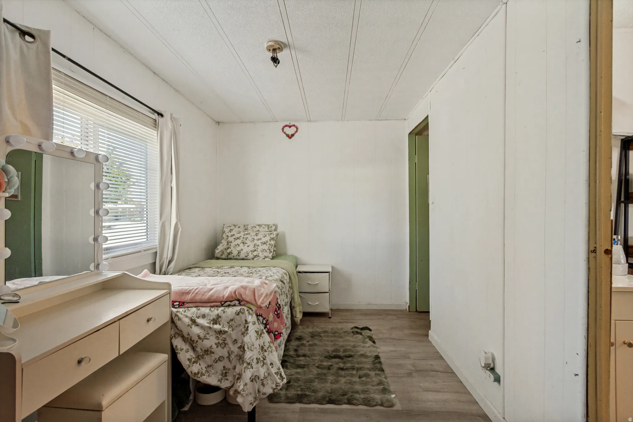 Wood-finish flooring with white wall paneling