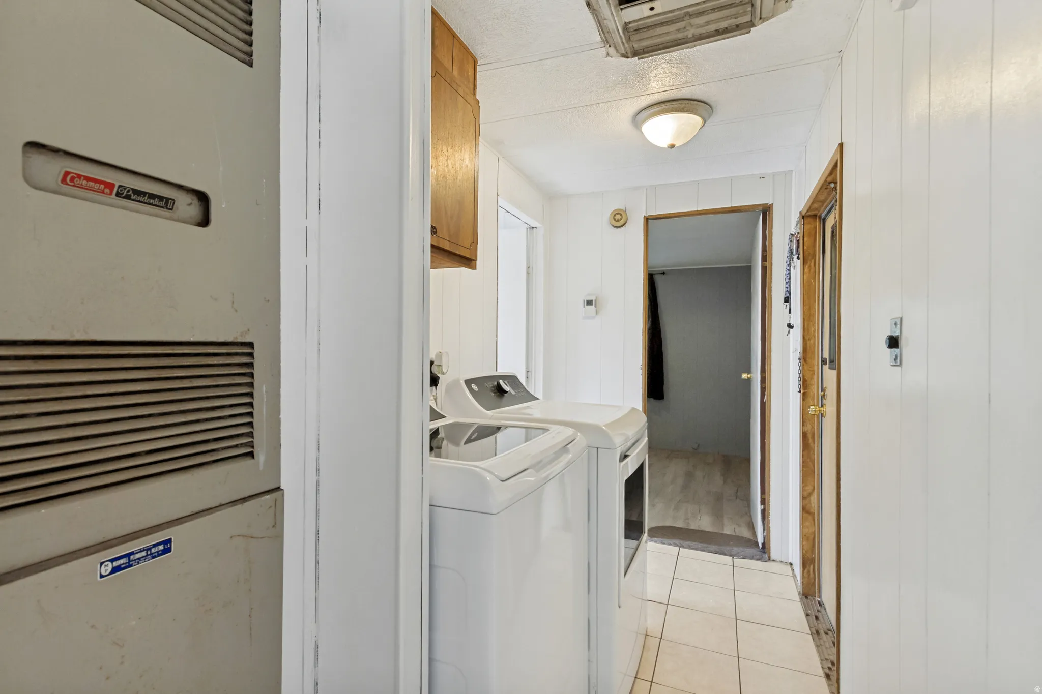 Utility area with tile flooring and a built-in overhead light fixture