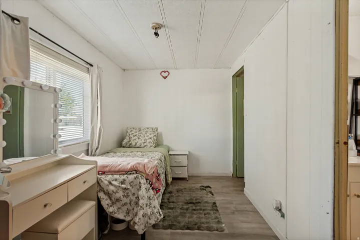 Wood-finish flooring with white wall paneling