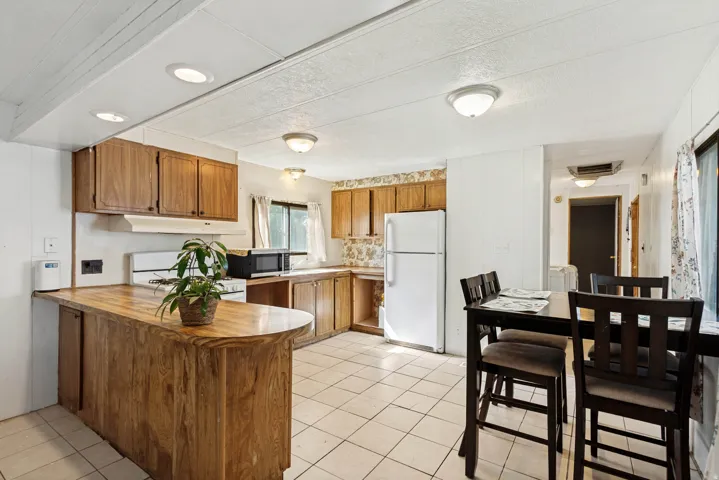 Kitchen featuring wood-finish cabinetry, tile flooring, and recessed lighting