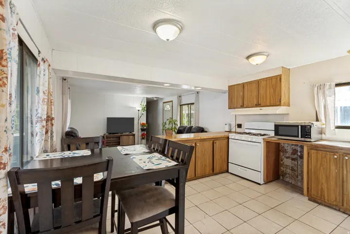 Kitchen featuring wood-finish cabinetry, tile flooring, and a white gas range