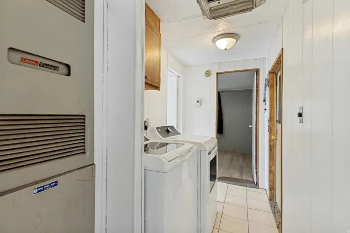 Utility area with tile flooring and a built-in overhead light fixture
