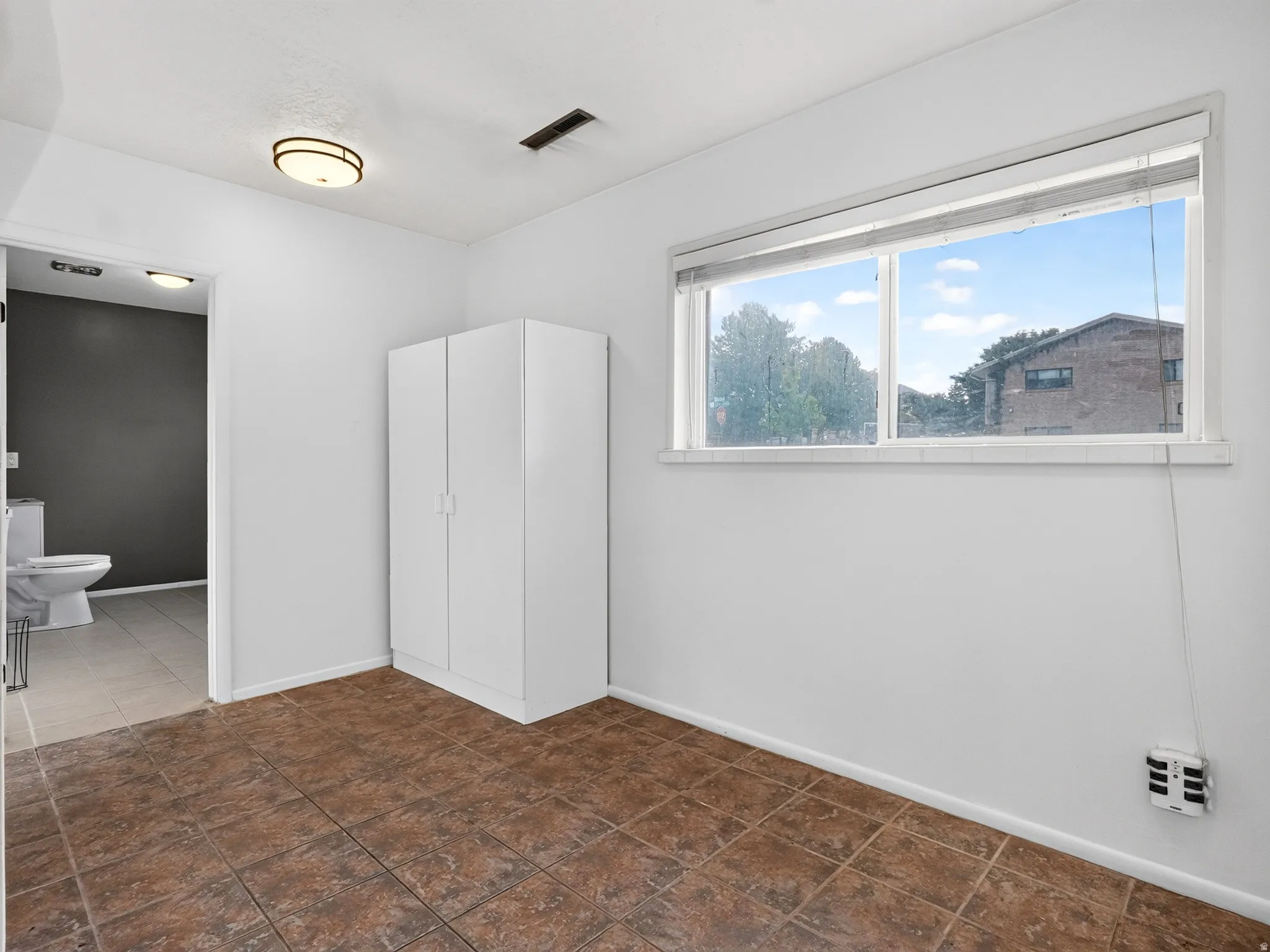 Spacious room featuring tile flooring and a bright window