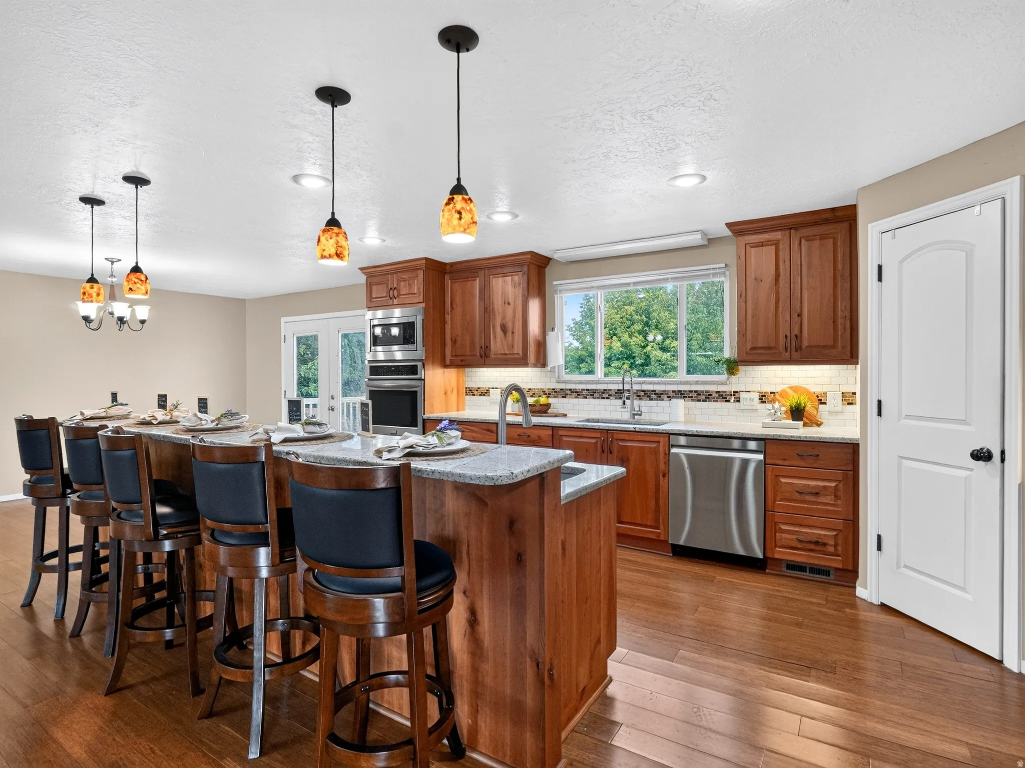 Kitchen featuring wood-finish flooring, recessed lighting, and a large island with pendant lights