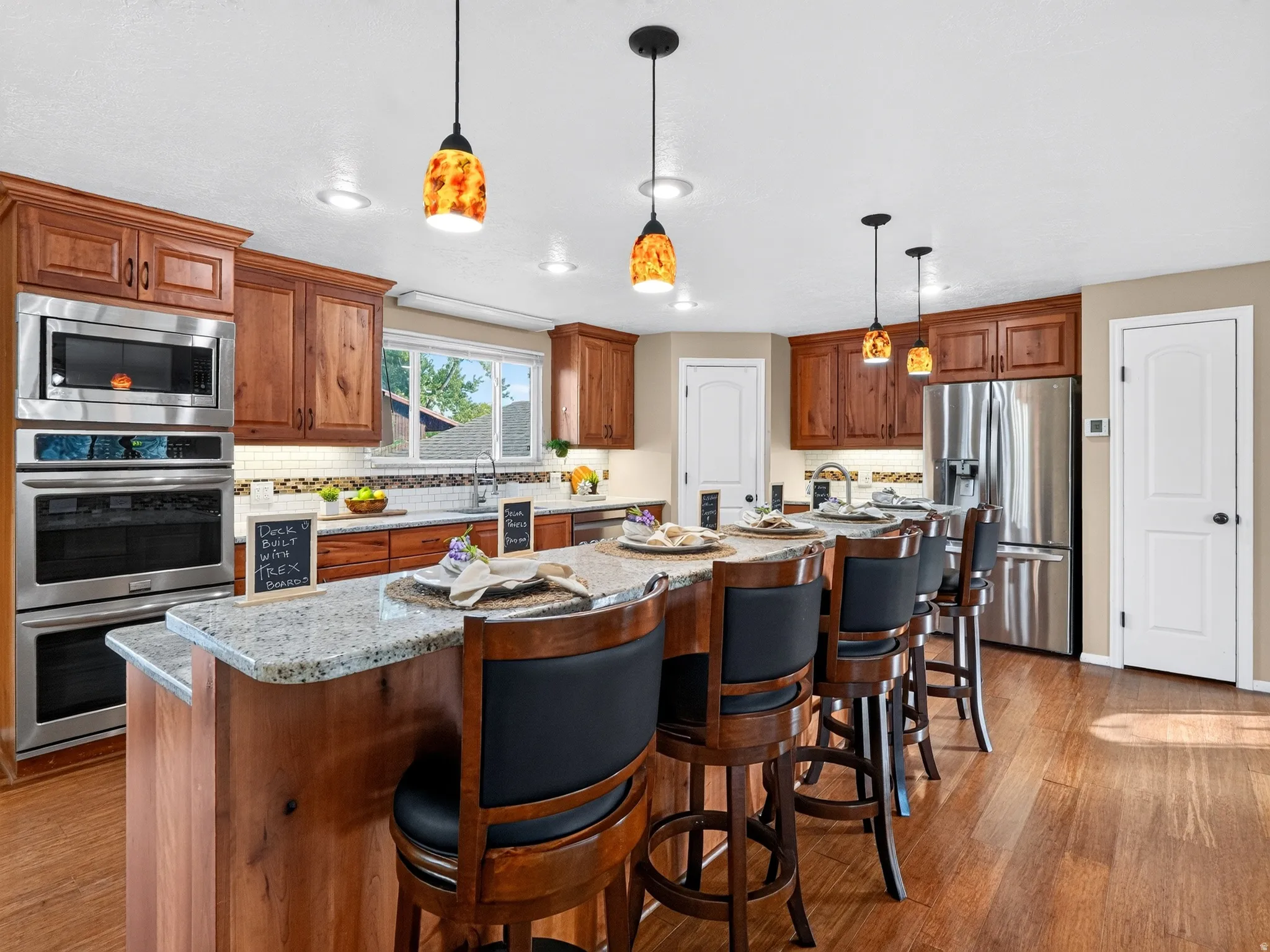 Kitchen featuring wood-finish flooring, recessed lighting, and a large central island with seating