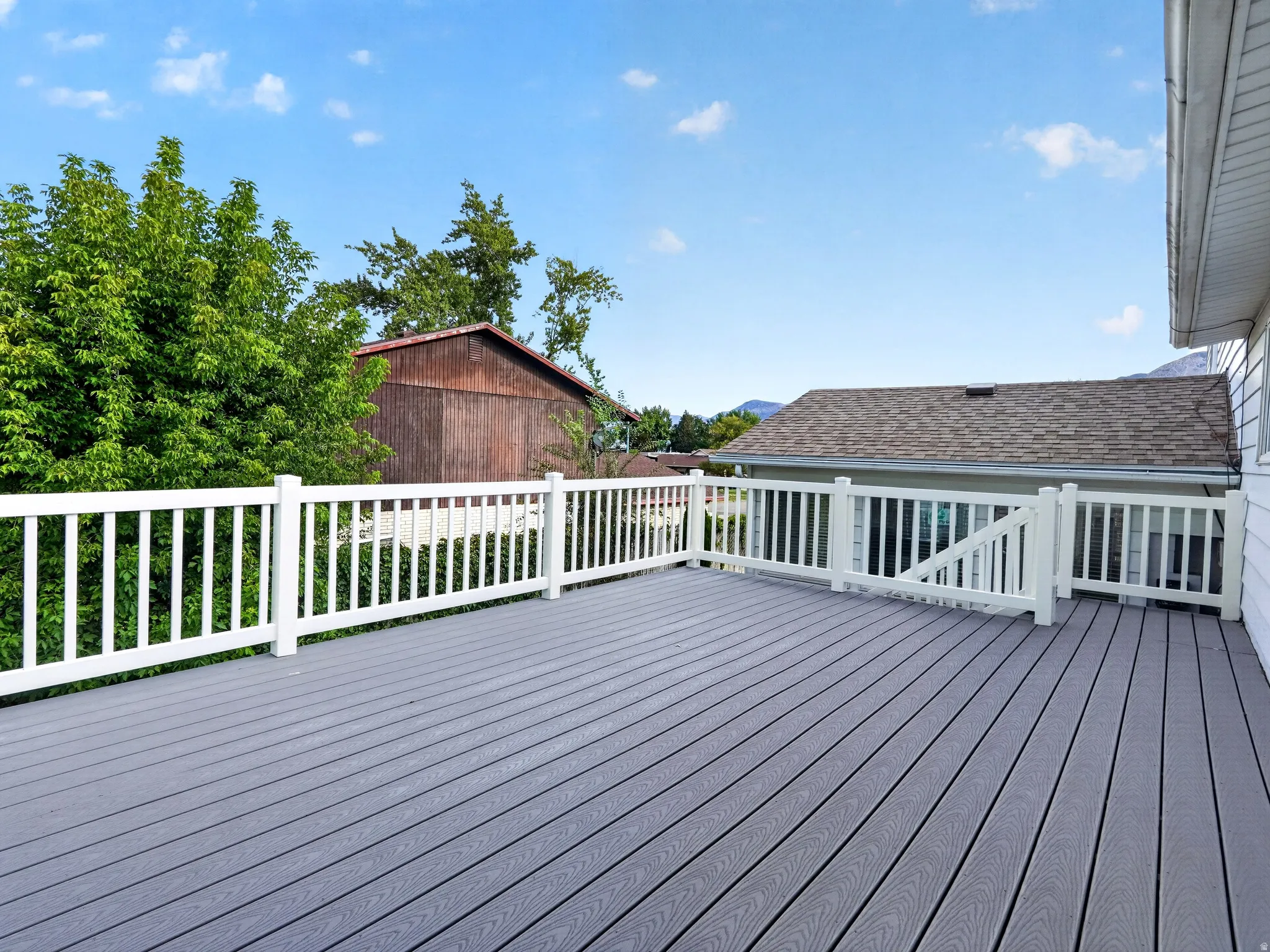 Spacious exterior deck with composite decking and white railing